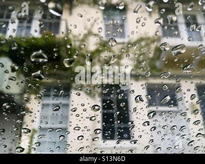 Raindrops on windshield looking at building with creeping vine Stock Photo
