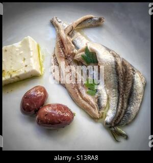 A healthy Mediterranean lunch of marinated fish, olives, and cheese Stock Photo