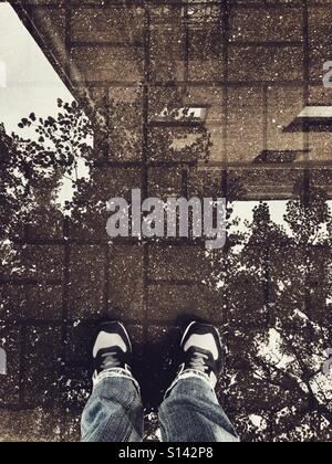 standing in a reflected puddle Stock Photo