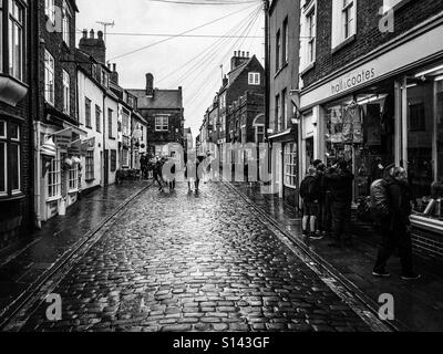 Church Street in Whitby. Wet cobblestones and people. Stock Photo