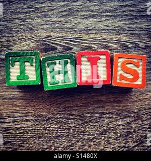 THIS word written with wood block characters Stock Photo