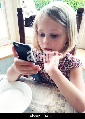 Girl playing on iPhone Stock Photo