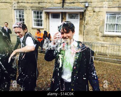 A student is covered in powder paint, silly string, confetti and champagne as he finishes his exams at the University of Oxford. This trashing is a tradition which has occurred for many years. Stock Photo