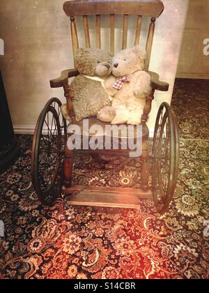 Old teddy bears on wooden wheelchair Stock Photo