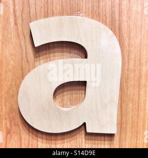 Lowercase Letter A in White Color Attached To Wood Background Stock Photo