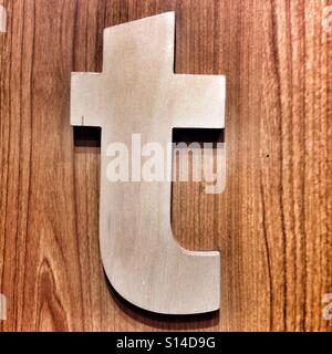 Lowercase White Letter T Hangs On Wooden Wall Background Stock Photo