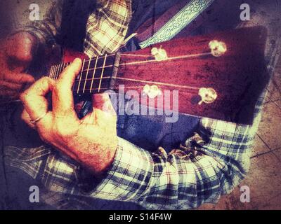 Woman playing a soprano ukulele, finger style Stock Photo