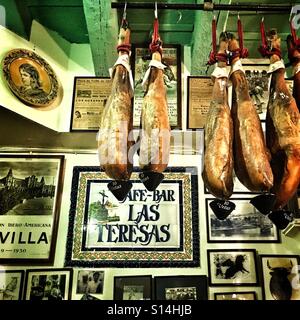 Legs of jamon iberico hanging in tapas bar Spain Stock Photo