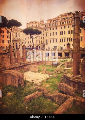 View of Largo di Torre Argentina square within the ancient Campus Martius, where Julius Caesar is believed to have been assassinated in 44 BC. Vintage paper texture overlay. Stock Photo