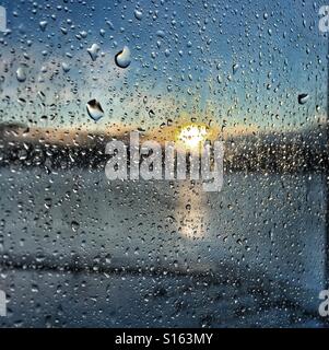 Sun coming up through a curtain of raindrops Stock Photo