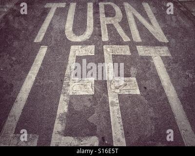"TURN LEFT" The words painted on the Tarmac, instructing road users to only Turn Left at the road junction they are approaching. Photo Credit - © COLUN HOSKINS. Stock Photo