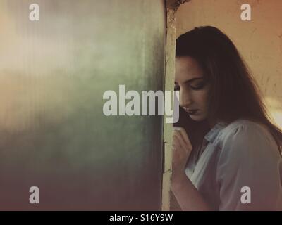 Sad woman by the window Stock Photo