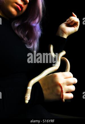 A teenage girl holding a snake. Stock Photo