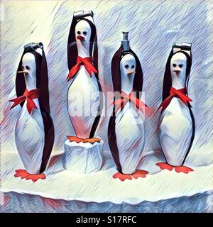 Four penguins that look like bowling pins holding the hockey Stanley Cup above their heads Stock Photo