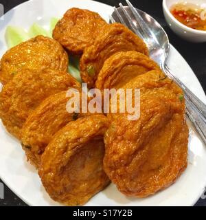 Thai style fried fish cake on a plate served with sweet dipping sauce, Bangkok , Thailand Stock Photo