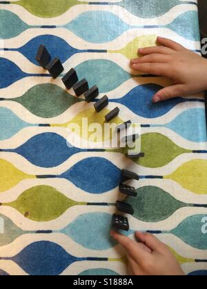 Dominoes and child's hand Stock Photo