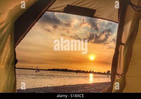 Sunset view from the entrance of a Hilleberg Staika tent. Outside off Löddeköpinge on the Swedish South West coast. Stock Photo