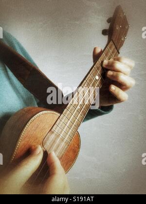 Playing a ukulele, finger style Stock Photo