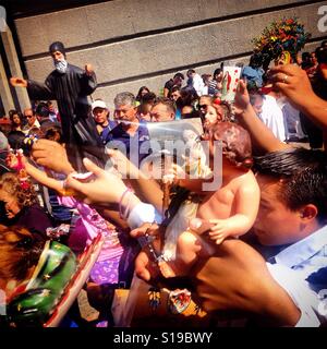 Pilgrims holds saints to be blessed with holy water in Our Lady of Guadalupe basilica in Mexico City, Mexico Stock Photo