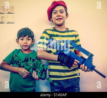 Boys playing soldier with plastic machine gun toy Stock Photo