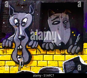 Two cartoon dogs leaning on a wall, one smoking Munich, Germany Stock Photo