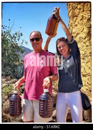 A happy couple holds their five litre bottles of tequila after shopping at a distillery in Tequila, Mexico. Stock Photo