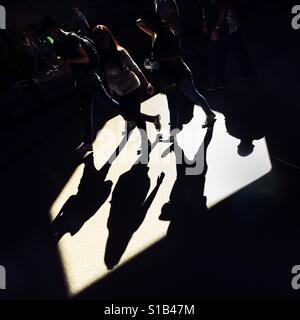 Passengers walk through a beam of light thrown on the platform of San Antonio metro station in Medellín, Colombia, 13 December 2016. Stock Photo
