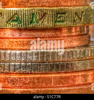 Small pile of British coins. Macro. Including a £1 coin, focus on 'amen' Stock Photo