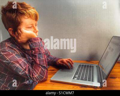 11-year old boy using laptop computer Stock Photo