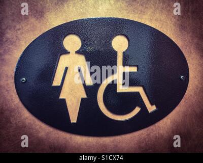 Oval sign, for women, also wheelchair accessible, outside a toilet, Canada. Stock Photo