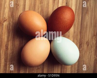 Four eggs on a wooden surface Stock Photo