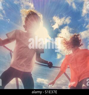 Two girls having fun bouncing on a trampoline Stock Photo