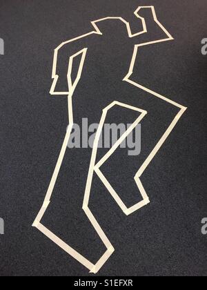 Masking tape outline of the human form on a carpeted floor. Stock Photo