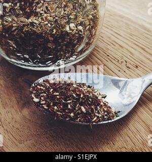 Za'atar spice mixture in a glass jar and on a spoon Stock Photo