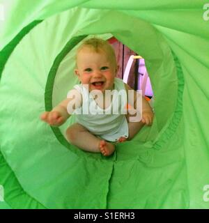 Eight month old baby boy playing in a tunnel Stock Photo