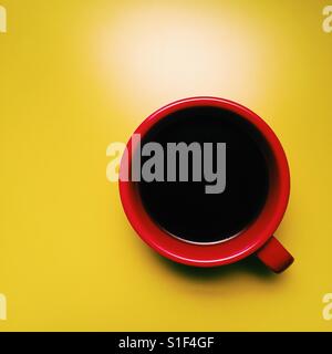 A fresh cup of black coffee on a yellow table Stock Photo