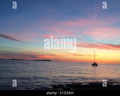 A boat on the waters of sunset strip, Ibiza Stock Photo