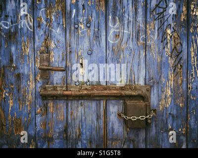 Rusty sliding door lock on weathered wooden blue door Stock Photo