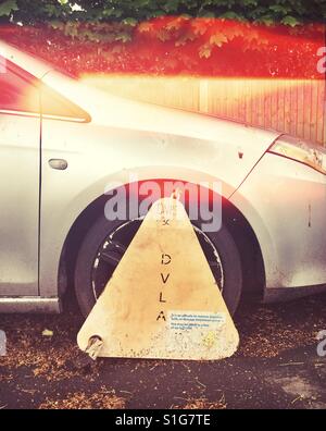 Wheel clamp on an illegally parked car Stock Photo