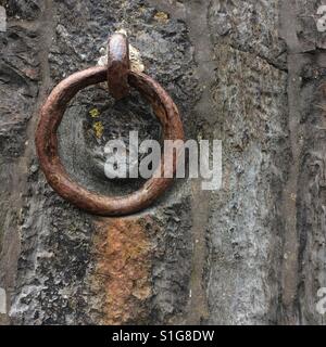 A rusty old mooring ring on the harbour wall at Polkerris, Cornwall Stock Photo