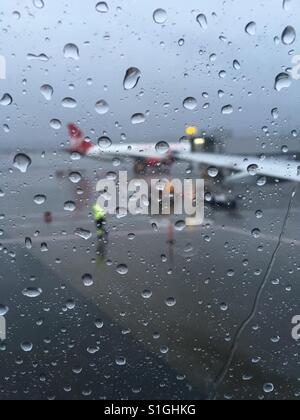 Raindrops on glass window at airport waiting lounge Stock Photo
