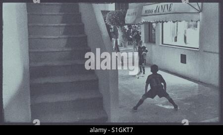 Two boys playing football in a Spanish Alley. Stock Photo