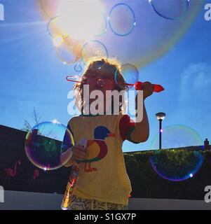 Boy blowing bubbles in sunny garden Stock Photo