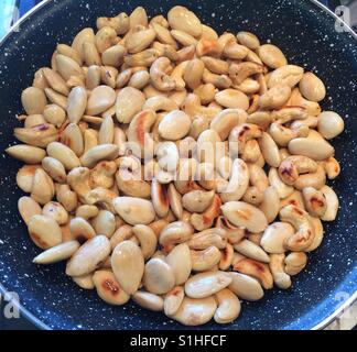 Roasting almonds and cashews. Stock Photo