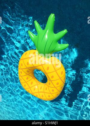 Pineapple pool toy floating on swimming pool water. Square crop Stock ...