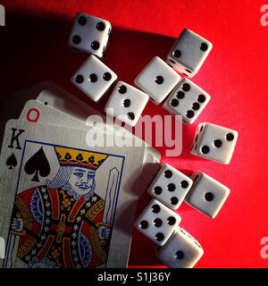 Close-up shot of eleven dice and a deck of playing cards showing the king of spades Stock Photo