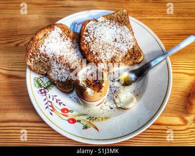 Boiled egg with wholemeal toast and cracked black pepper and salt Stock Photo