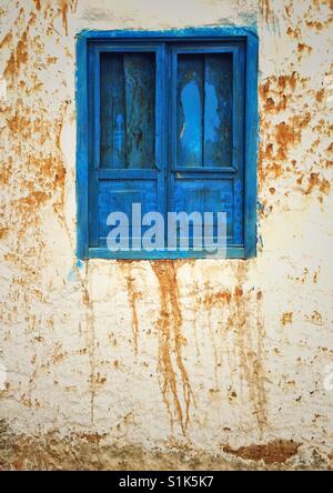 Bright blue painted window with close shutters on an old stucco wall in Cusco, Peru Stock Photo
