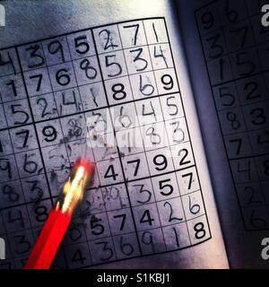 A motion blurred pencil eraser wiping out a mistake in a sudoku puzzle Stock Photo