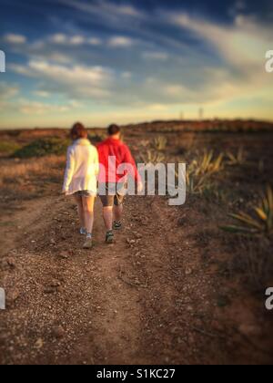 Couple walking  on a pathto watch the sunset in Sagres, Portugal. Stock Photo